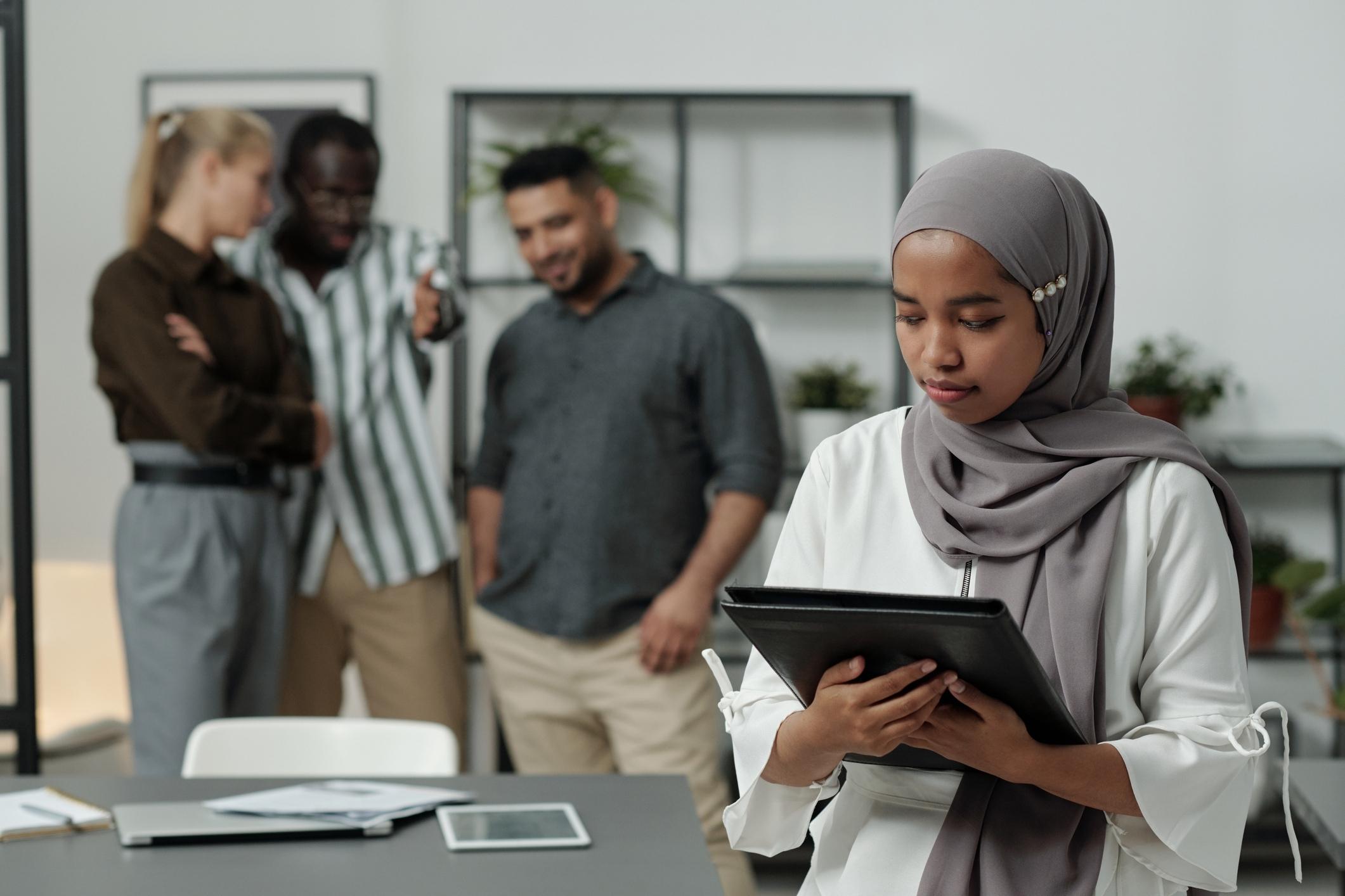 A woman in a hijab facing discrimination at work despite being under FEHA protected classes.